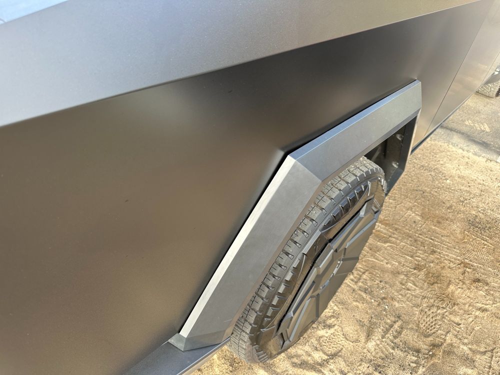 A wheel arch leans out from the vast expanse of of the Cybertruck's entirely flat bed flank panels, creating a cave at one corner, whose dark expanse lures the eye in. From here it looks like the widest entrance point could fit a child's fingers, just to pick a random example, although the unevenness of the seam suggests that said child's fingers would then quickly become stuck. More to the point, it just looks cheap and shitty for a Fisher Price toy, let alone a six figure truck.