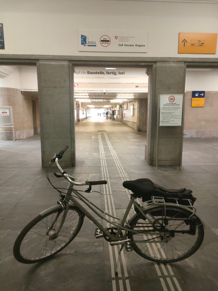 Photo du passage douanier en gare de Basel Bad. Des panneaux indiquent aux voyageurs qu'ils peuvent être contrôlés.