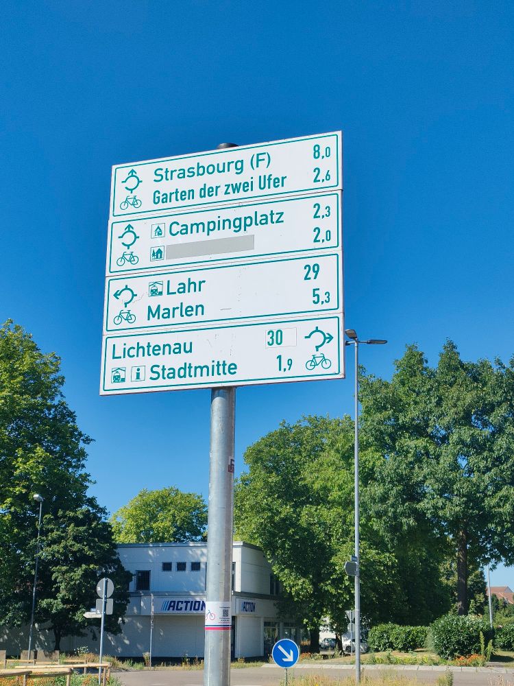 Photo de panneaux de directions cyclables avant un rond-point à Kehl. La direction de Strasbourg est tout droit à 8 kilomètres.