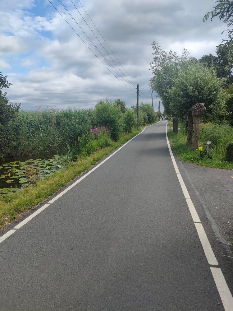 Photo d'une route à faible trafic le long d'un canal entre Gouda et Worden