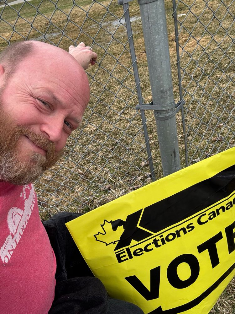 Me in front of a directional sign at the advance polling station. 