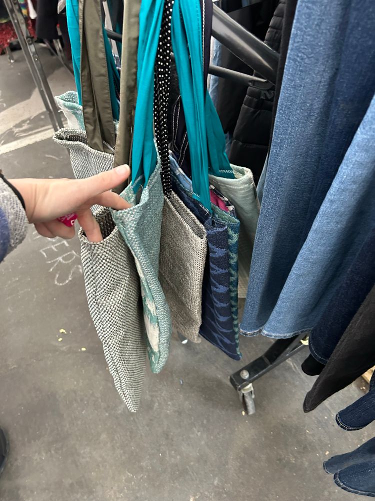 A variety of tote bags made from fabric scraps. These few are blue. 