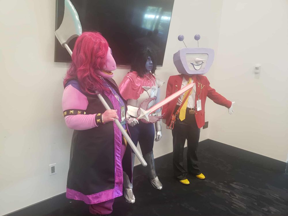 People cosplaying Susie, Kris, and Tenna from Deltarune