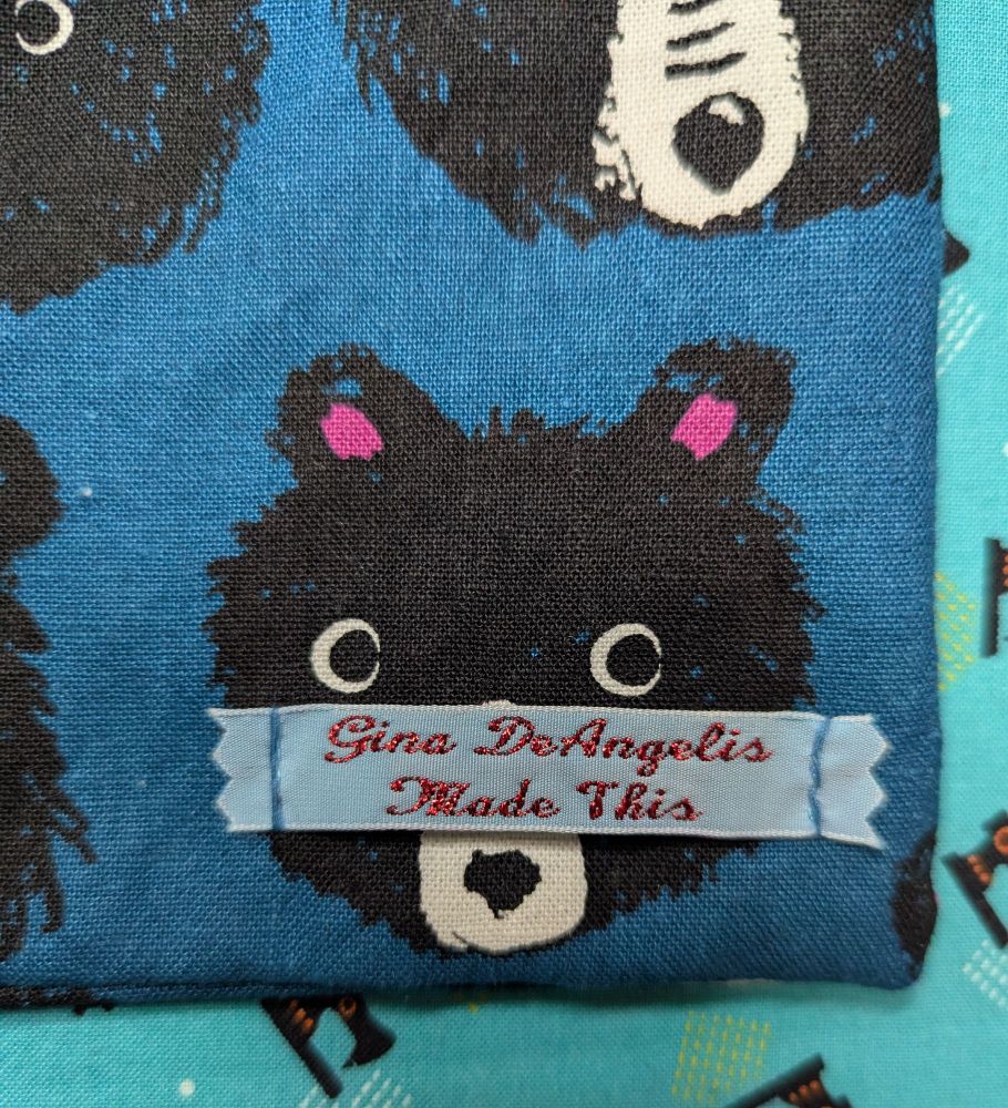 The corner of a pillow sports a blue label with red script reading "Gina DeAngelis Made This"