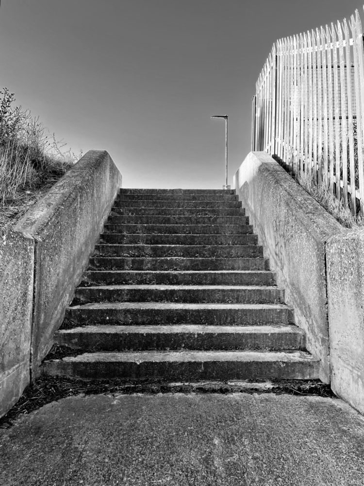 Concrete steps, street lamp and metal fence at Cullercoats Bay. 