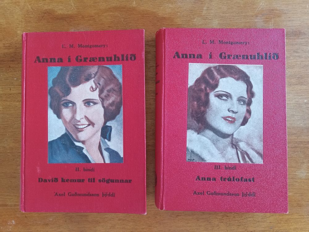 Two red hardcover books on a table, each consisting of an illustration of a red-headed woman with a 1930s wavy bob.