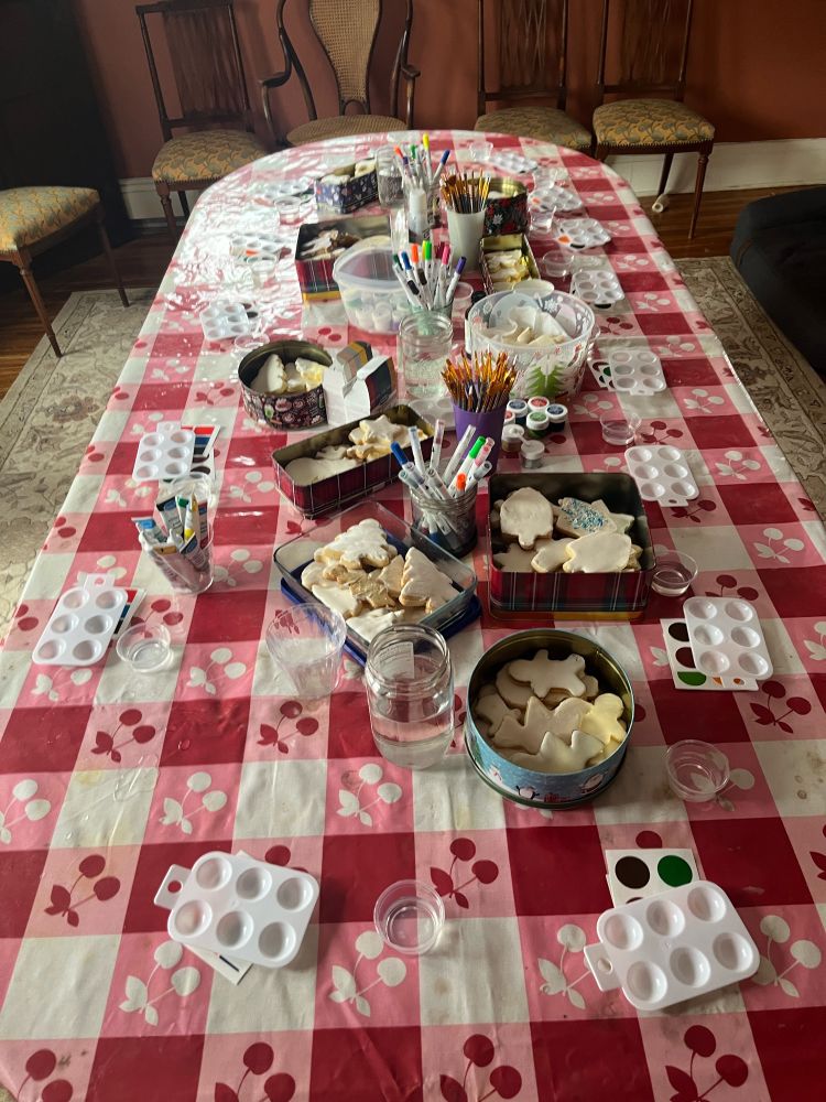 Table set with edible paint pallets and tins of holiday cookies