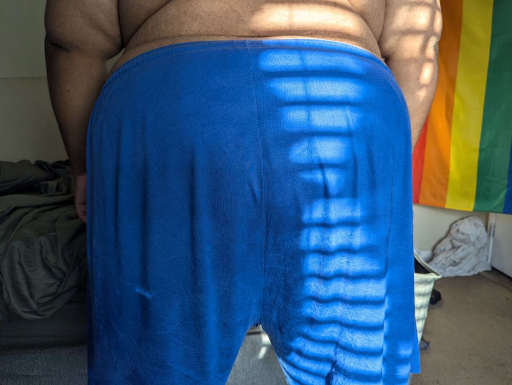 Superchub standing with his back to the camera, showing off his wide backside