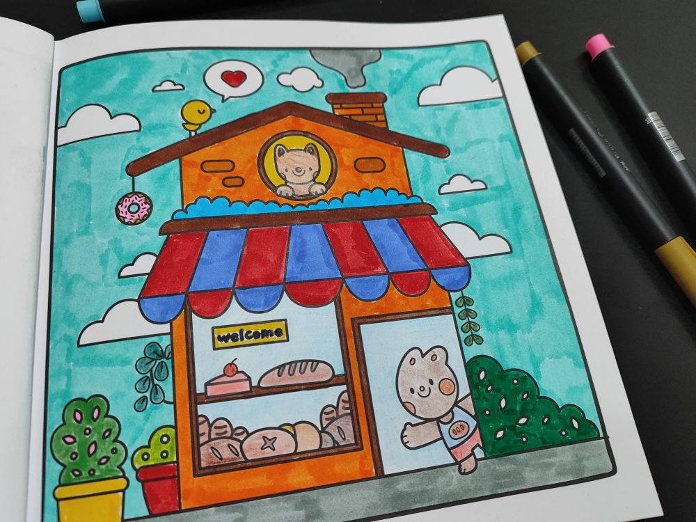 Livro de colorir Mundo Fofurinha, da Rafa Harger. O desenho é de uma padaria fofa.