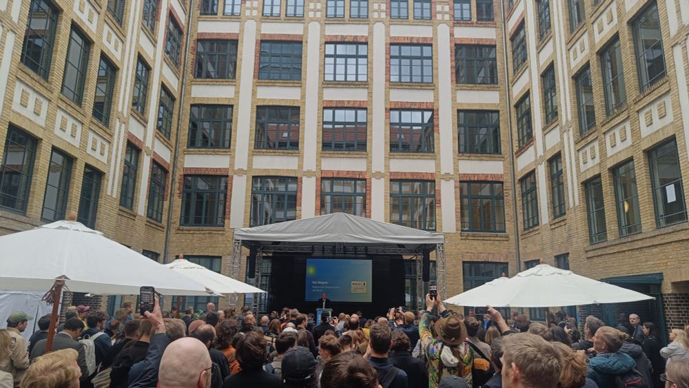 Picture of the inner yard of the berlin house of game office building with audience and politicians talking :)