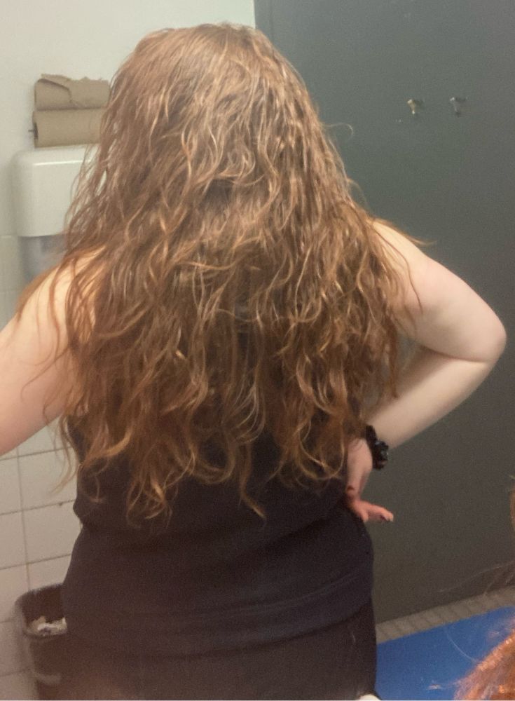 Evie with her back to the mirror, red curls streaming down her back. It’ll look damn cute tomorrow when the gel finally sets 