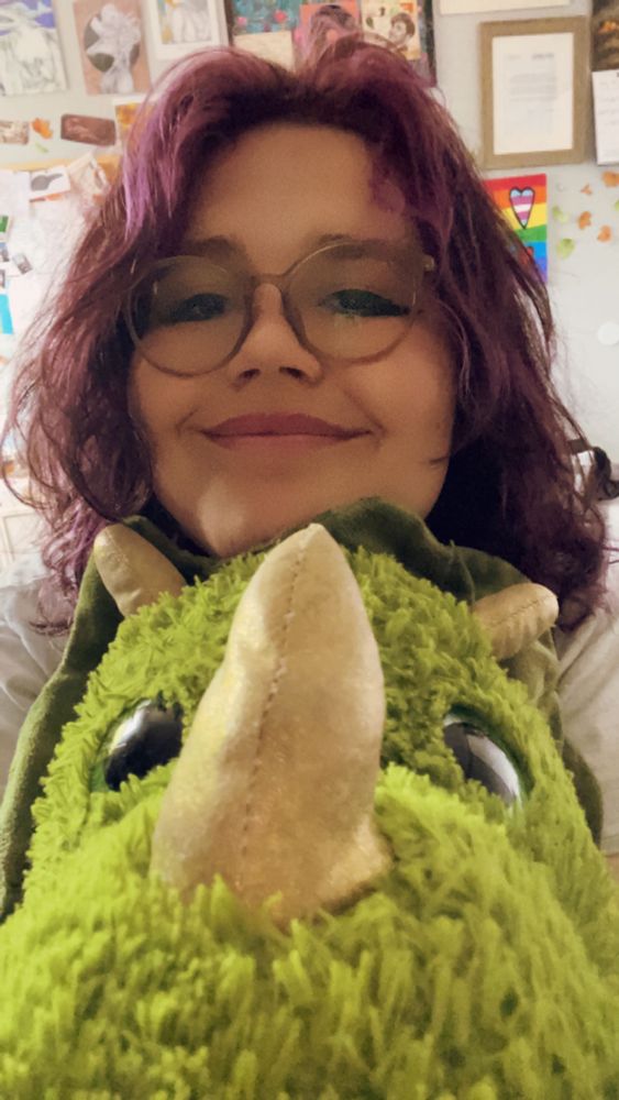 a really cute picture of me smiling with my stuffed triceratops