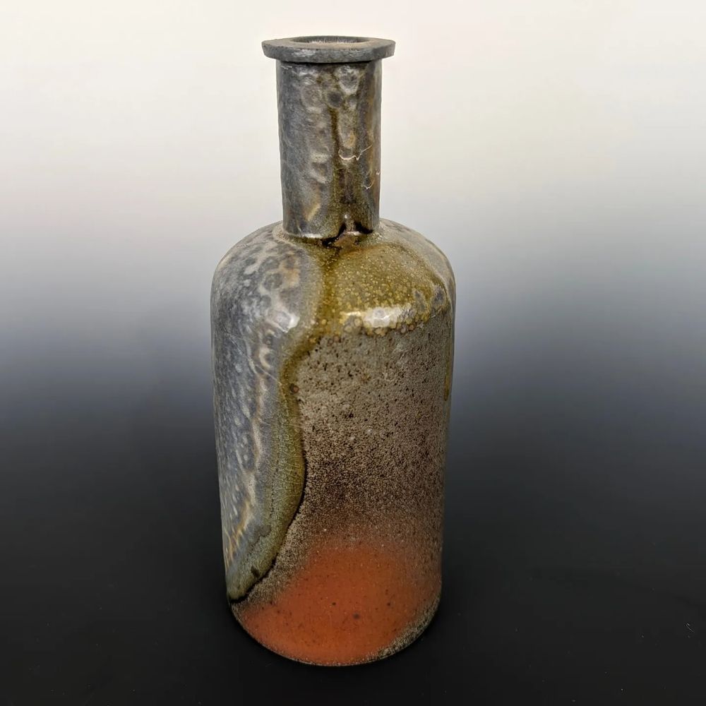 Woodfired round ceramic bottle with heavy wood ash on one side, red flashing on the other, sperated by a band of green ash.