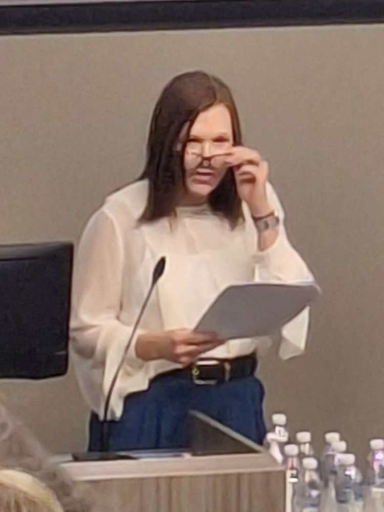Liz Crowe, Wellbeing Specialist, RBWH, standing at podium looking over her glasses like a stern librarian.