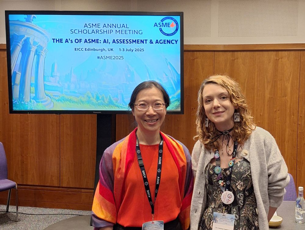 Rhea and Cristina in front of the #asme2025 conference holding slide. 