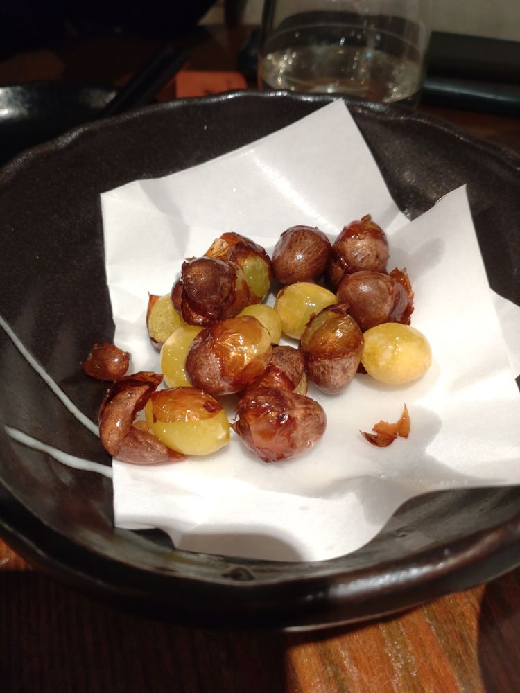 黒い器に白い油取りの紙、その上に素揚げの銀杏が乗っている。