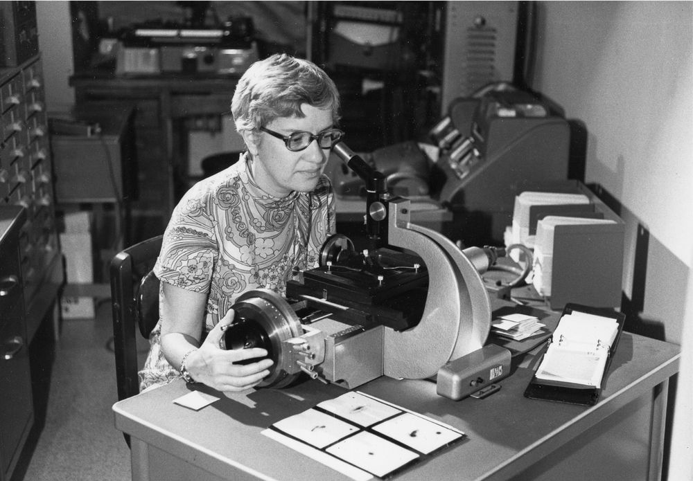 Vera Rubin at Carnegie Science’s former Department of Terrestrial Magnetism, now part of the Earth and Planets Laboratory, in 1972 using her “measuring machine” to analyze photographic plates. In the 1970s Rubin and collaborator Kent Ford collected data on dozens of spiral galaxies. Rubin’s measurements of the spectra data consistently showed flat rotation curves, providing the powerful observational evidence that supported the existence of dark matter. Credit: Carnegie Science