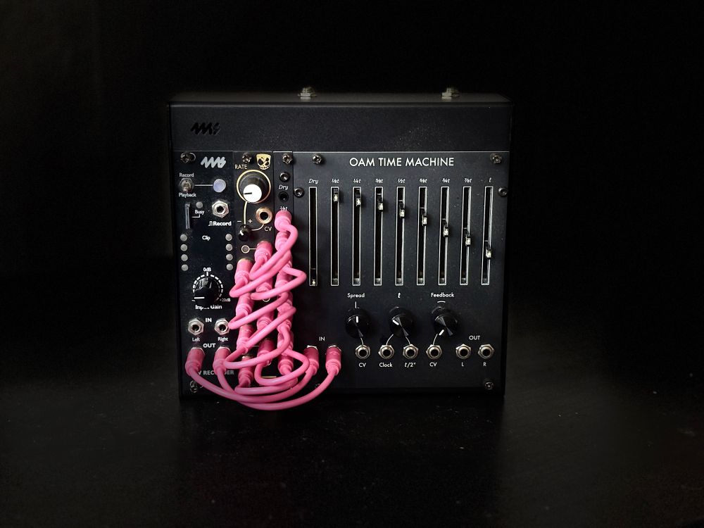 A 34 HP 4MS pod34X containing a 4MS Wav Recorder, an Instruō øchd, and an OAM Time Machine with a 2 HP expander that has nine sockets on it. All of these modules are patched up together using short, pink patch cables.