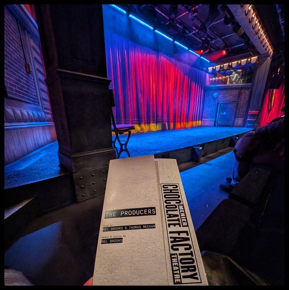 The programme for 'The Producers' with the stage in the background 