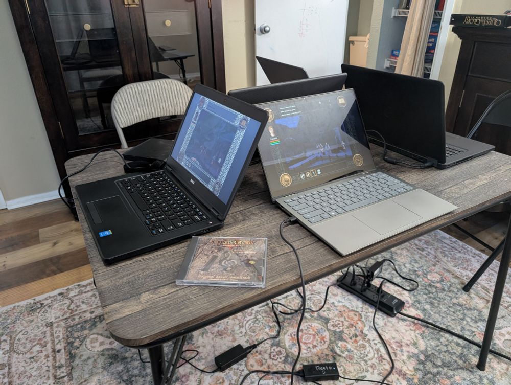 Four laptops on a folding table playing the Quest for Glory 5 multiplayer demo.