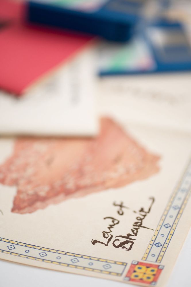 Close up of the map of Shapeir from Quest for Glory 2, with disks and manuals visible in background. Text reads "Land of Shapeir."