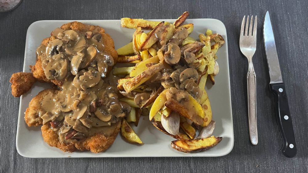 A jägerschnitzel with oven potatoes and a mushroom sauce. 