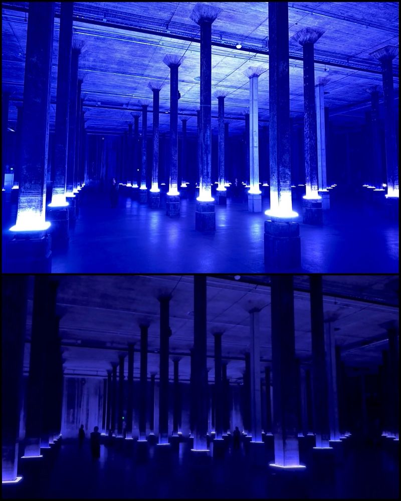 a photo of a vast subterranean tank full of thin columns, lit up mysteriously - blue light