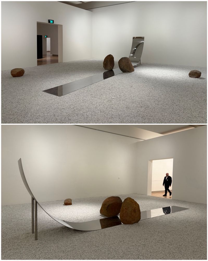 two views of a minimalist sculpture using rocks, pebbles, and a shiny metal curve