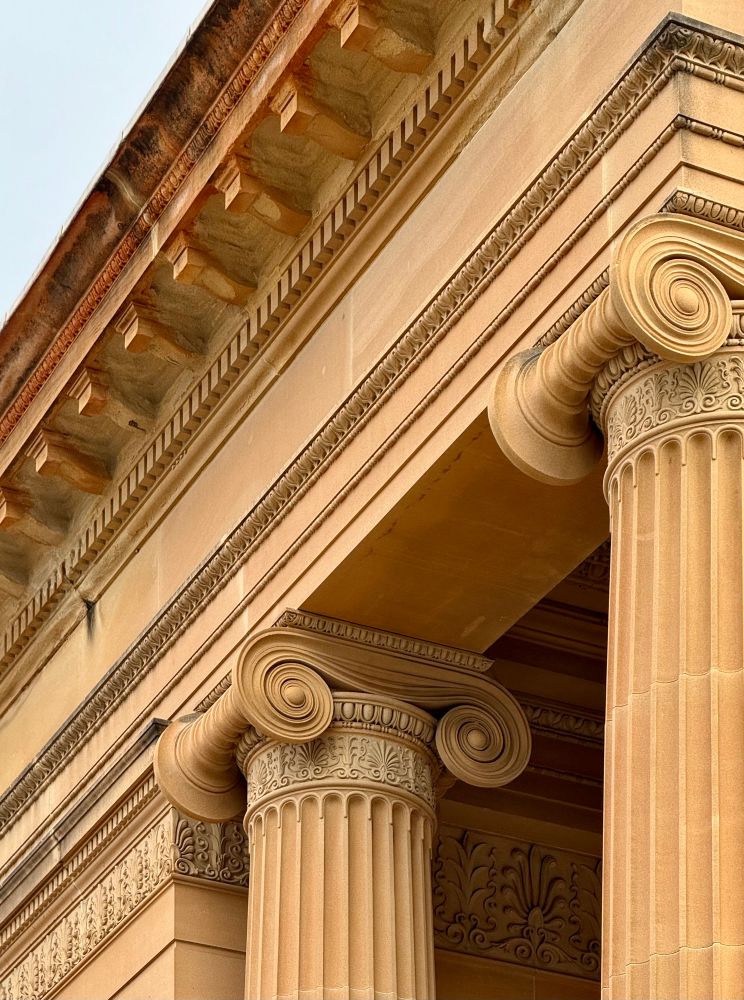 Ionic scrolled column capitals in golden sandstone