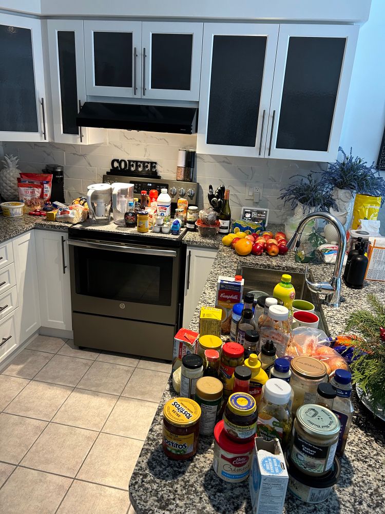 Picture of the fridge contents all over the kitchen waiting to be returned to a clean fridge.