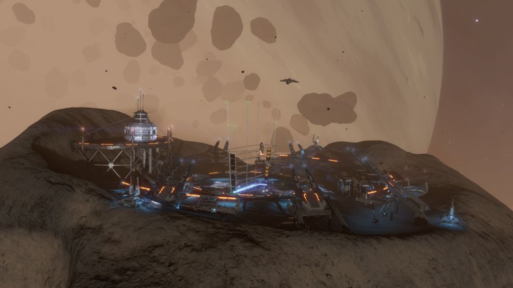 A view of the exterior entrance to an asteroid station, which is situated in a planetary ring around a gas giant shown in the background l behind an assortment of asteroids.