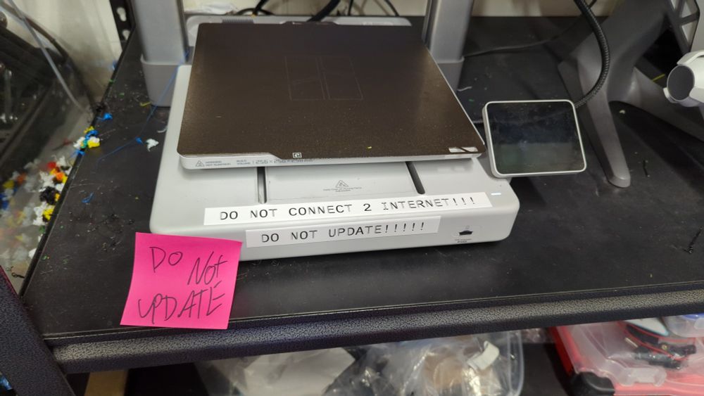 A bambu labs A1 printer with stickers on it that say DO NOT UPDATE!!!