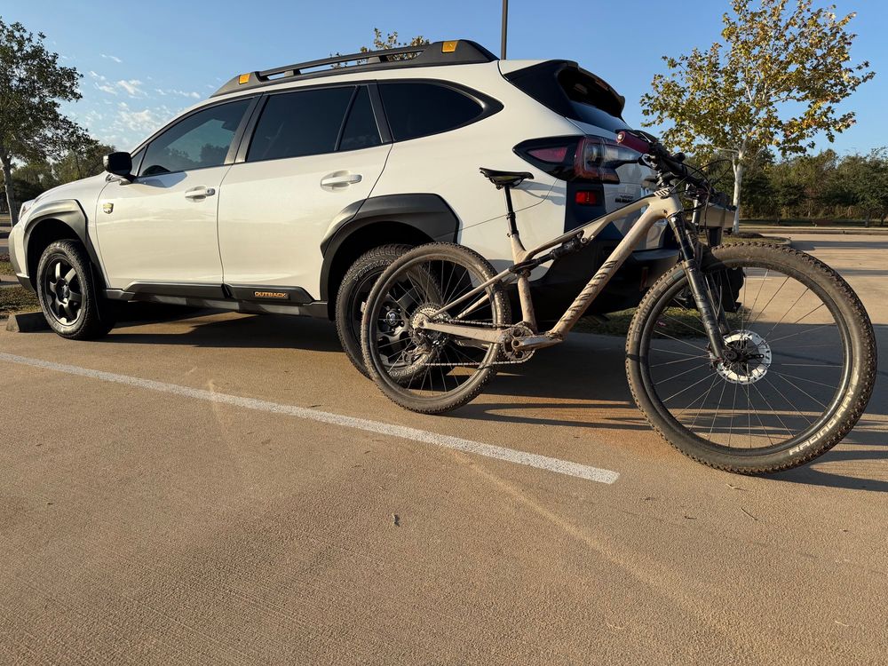 Clean white wagon and a dirty mountain bike 