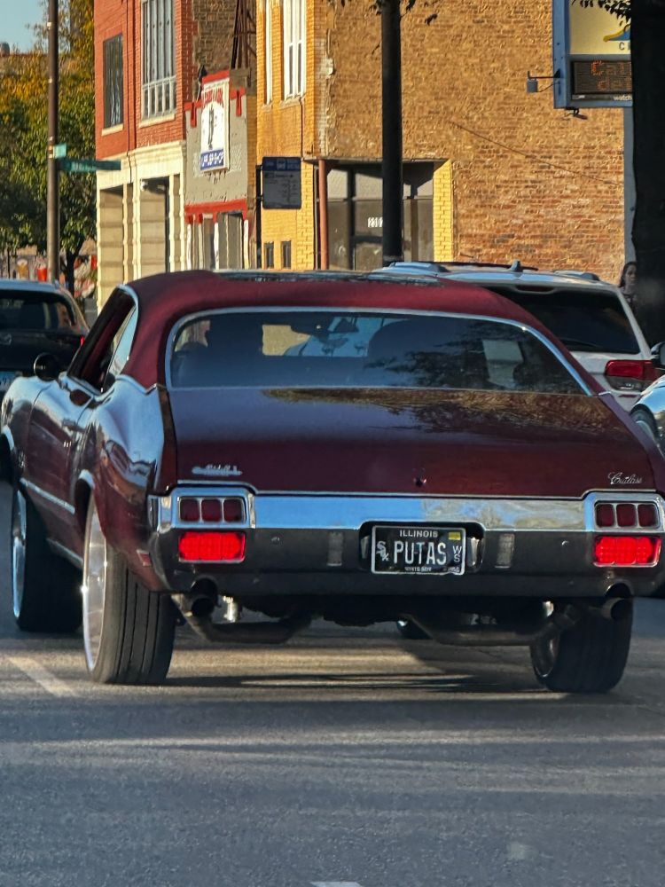 A red Oldsmobile Cutlass with a White Sox vanity plate of PUTAS