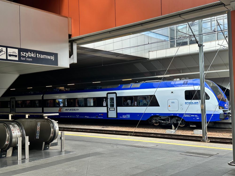 A shiny new train at Kraków Główny, with a sigh to the fast tram. 