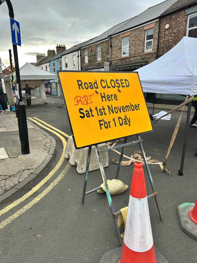 Road Closed sign with stalls being set up 