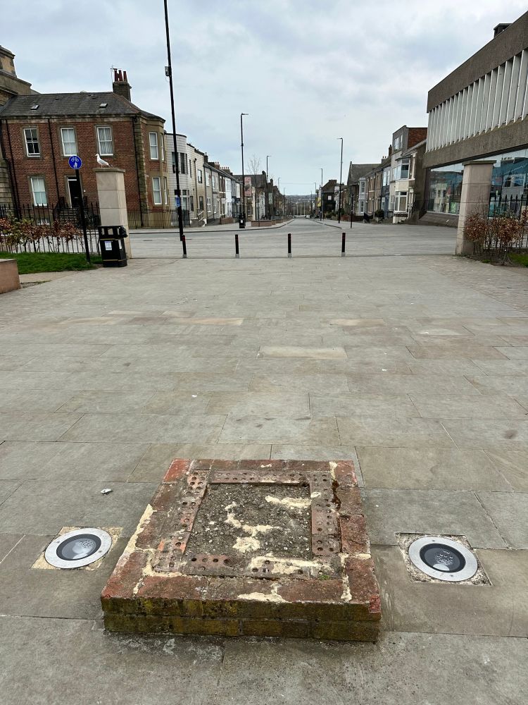 An empty plinth in Northumberland Square, North Shields, looking down Howard Street. 