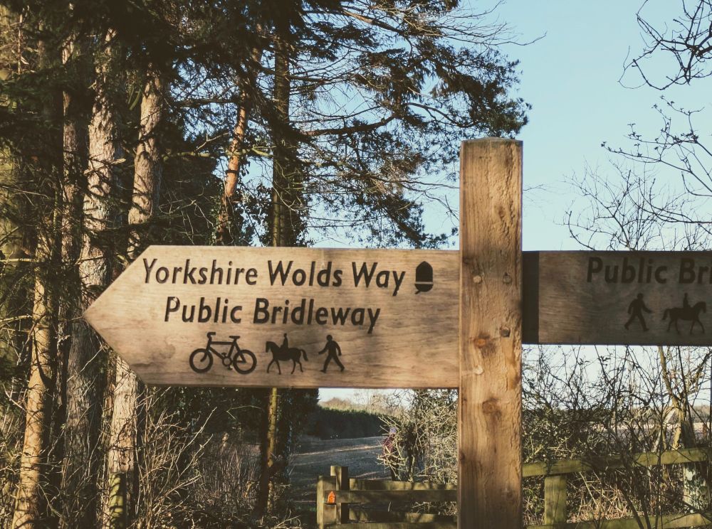 Wooden sign saying Yorkshire Wolds Way Public Bridleway
