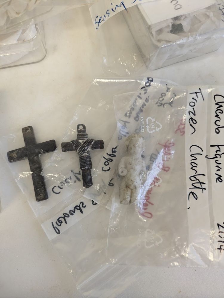 Plastic bags containing crucifixes and a small white figurine called a 'Frozen Charlotte'.