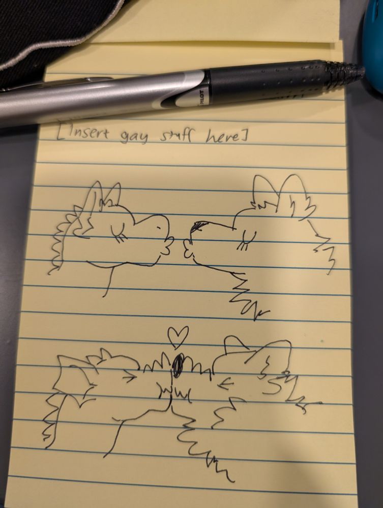 A dragon and a wolf making kissy faces at each other. They attempt to kiss but just scrunch their snouts up against one another, with a heart above them. 