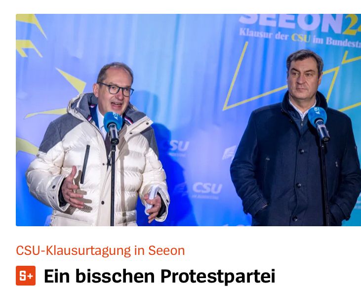 Foto von Dobrindt in weißglänzender Daunenjacke. Söder guckt sparsam.