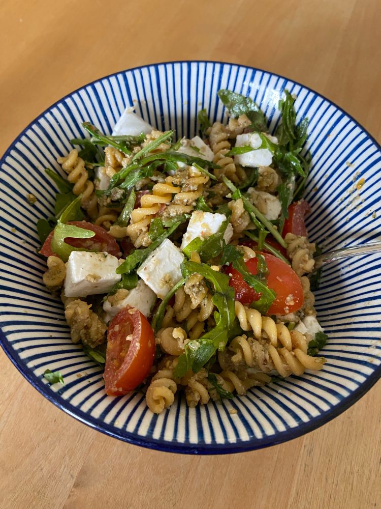 Foto von italienischem Nudelsalat mit Ruccola, Tomaten, veganem Feta