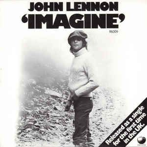 Cover of John Lennon's "Imagine" album.

Lennon himself is on this cover, in the middle, under the album title.

A hat is on his head, as he wears a turtle neck sweater, and dark colored pants.

Behind him are disorgainzed shapes that could be (ripples on water) might be piles of recycled electronics.