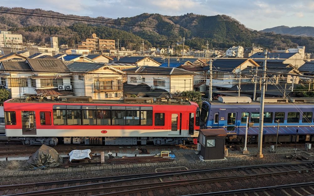 A red train and blue train connected on a rail