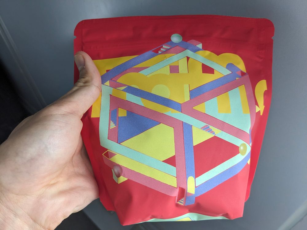 Red bag with a colourful Escher cube