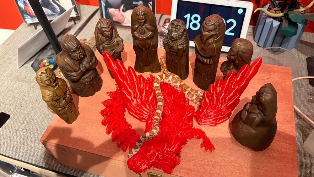 The eight forsaken statues stand in a semicircle around a red dragon, with a white and red cornsnake slithering on and around them