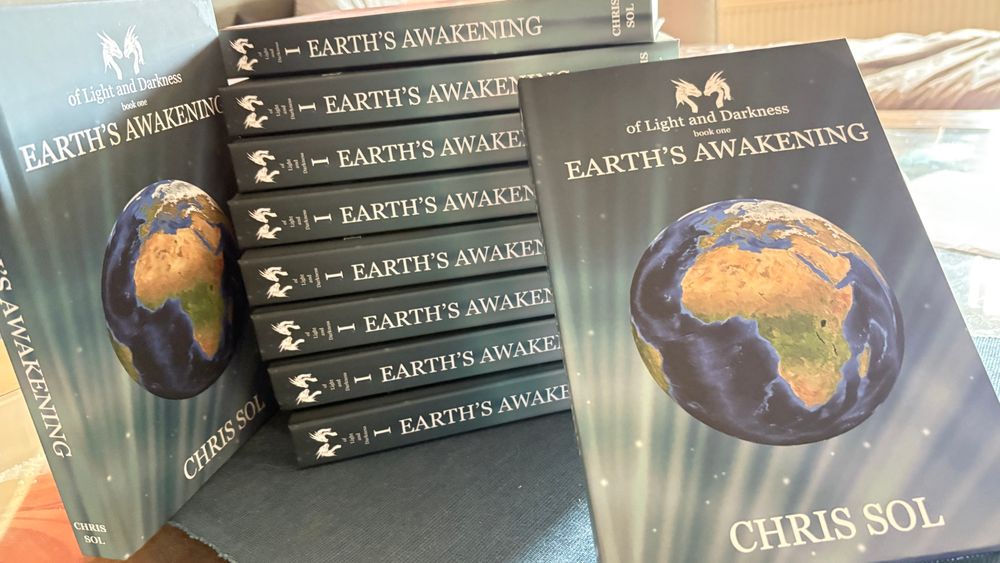 A stack of books, and the front visible on two, the front cover is of Earth’s Awakening featuring a starry background with Light emanating from the corner. The earth is depicted, showing the angle of Africa and Europe. 