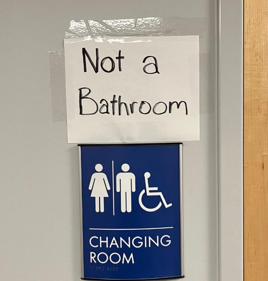 'Changing Room' Schild. Darüber handschriftlich 'Not a bathroom'