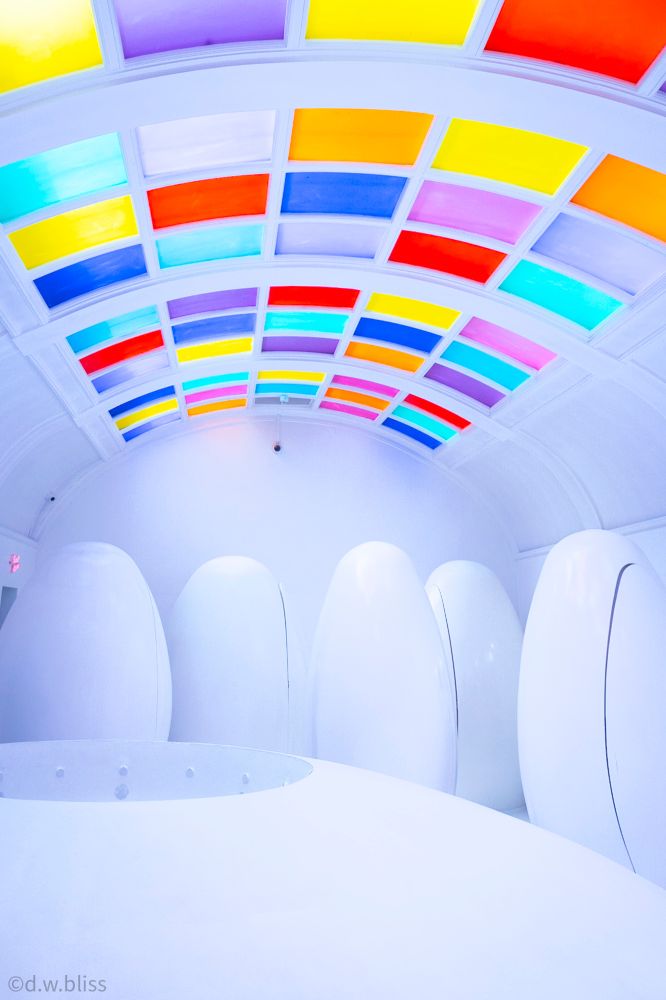 White room with egg-like structures under wildly colorful ceiling. Copyright d.w.bliss
