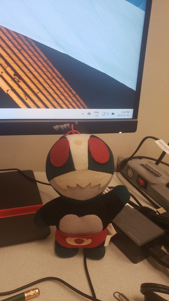 a vintage plushie of Kamen Rider Nigo, who is looking a little beaten-up